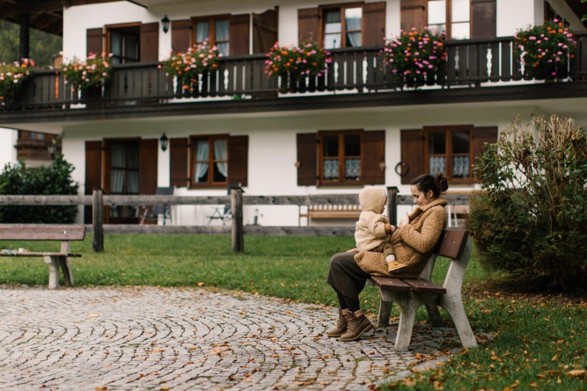 Mother and child sitting outside of house contemplating relocation orders during the covid pandemic