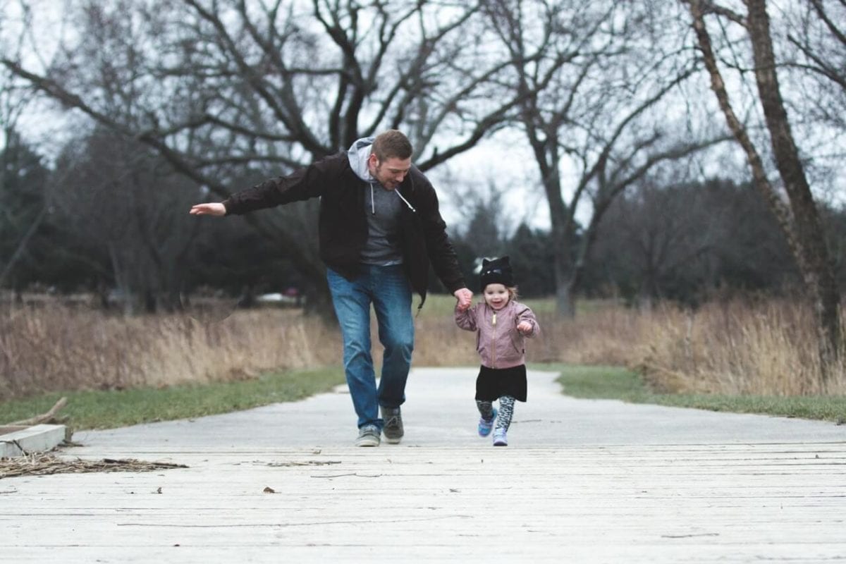 Father and daughter healthy running outdoors co-parenting