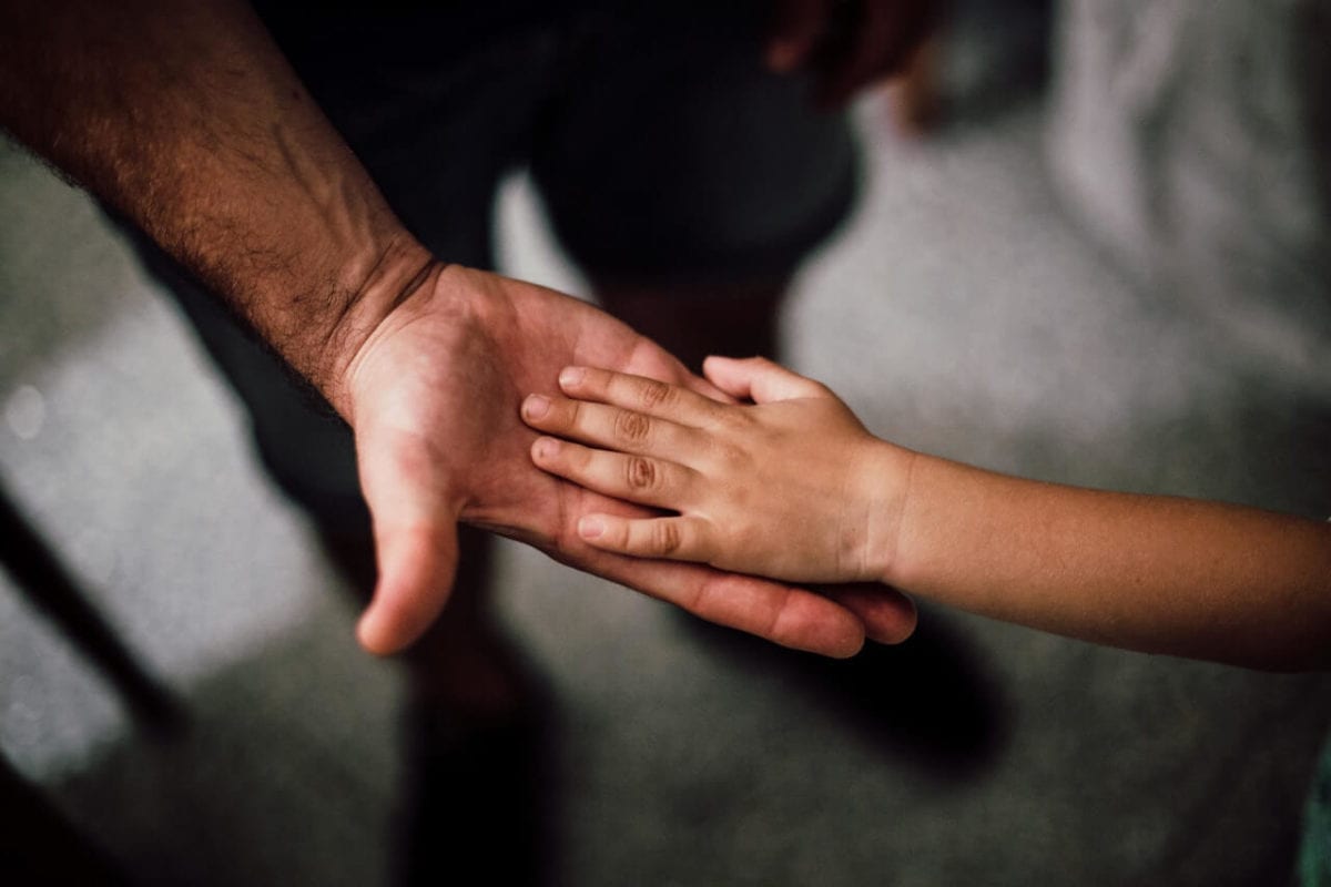 Parent and child support payments holding hands