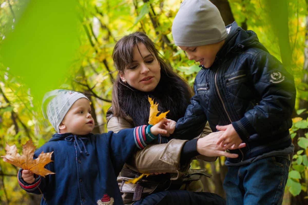 Mother plays with children on an ideal child custody schedule by age in Australia agreement.