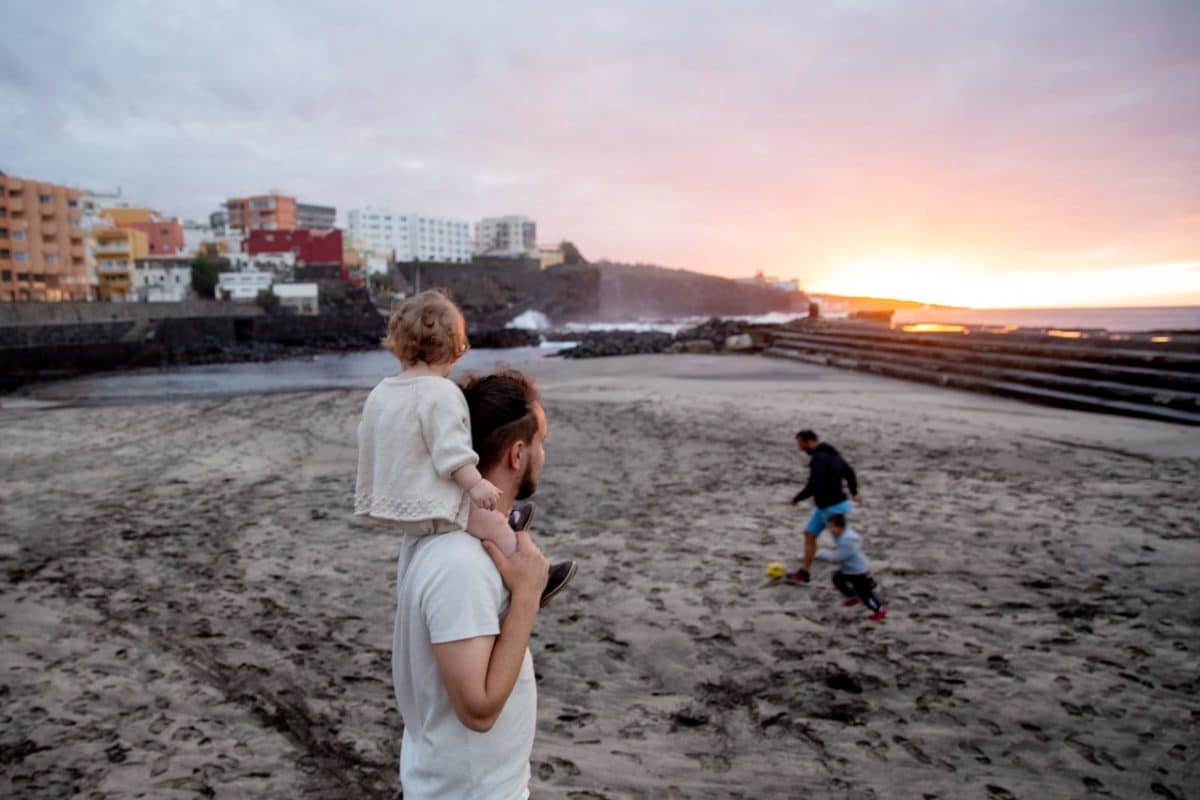 Father stands on beach with son pondering parenting and relocation after separation divorce