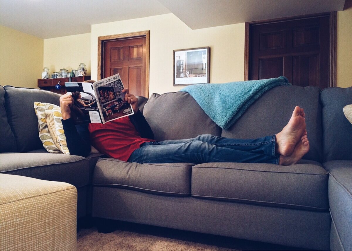Reading magazine on couch