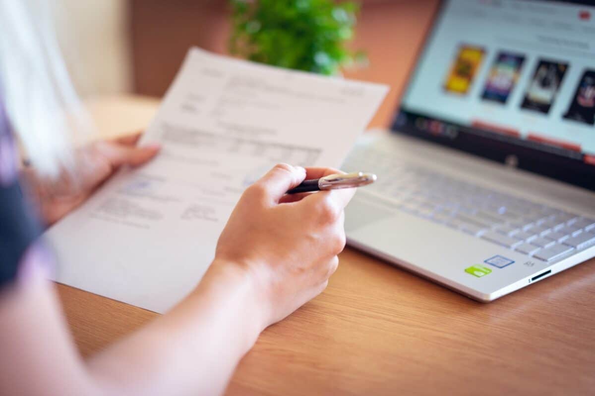 Person with documents and pen and laptop prepared for full and frank duty of disclosure