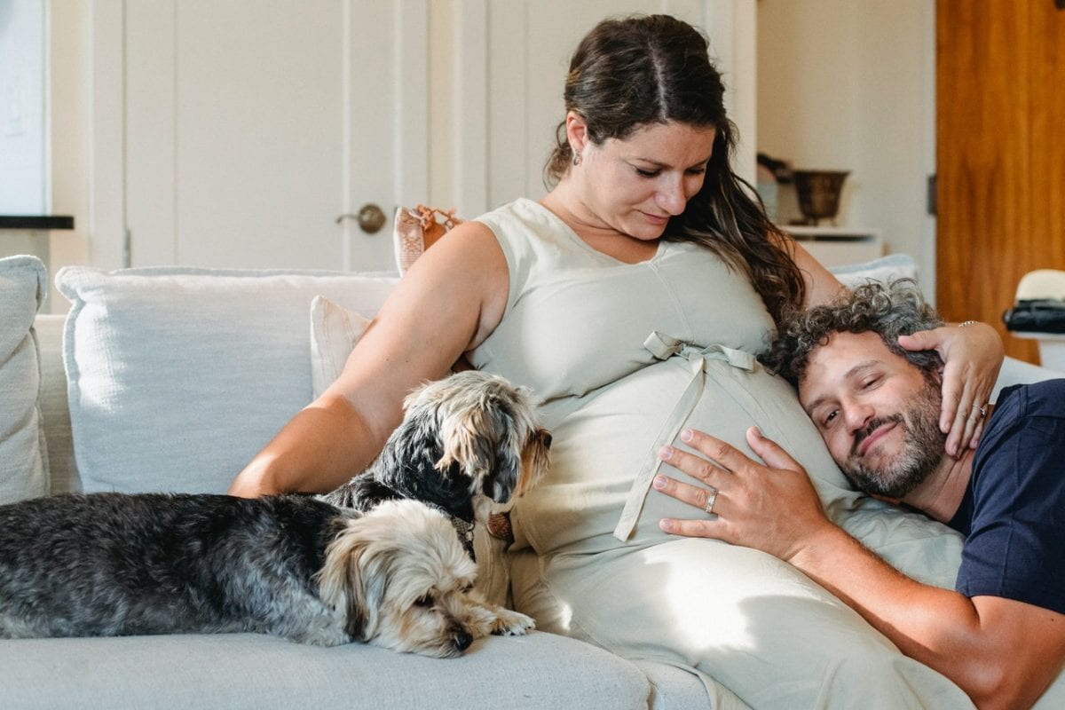 Happy couple on couch with dog enjoying prenup benefits