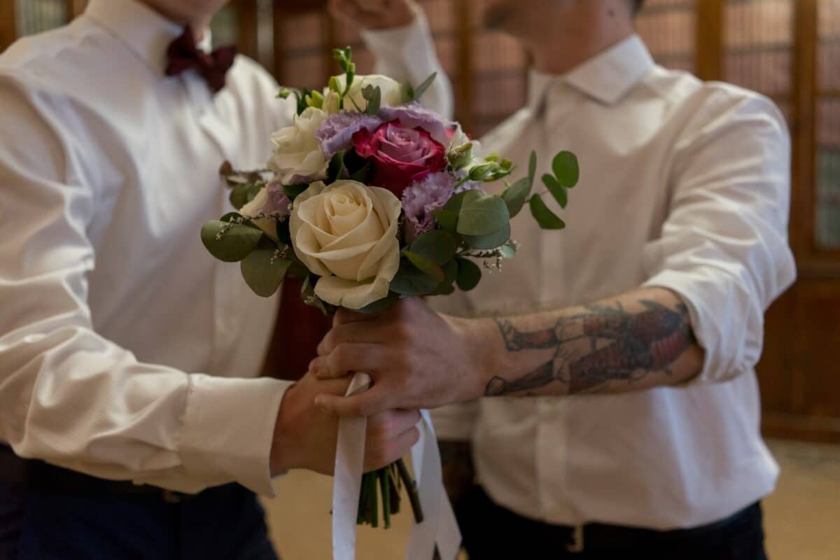 Two men holding bouquet and hands symbolic of Gay divorce rates in Australia