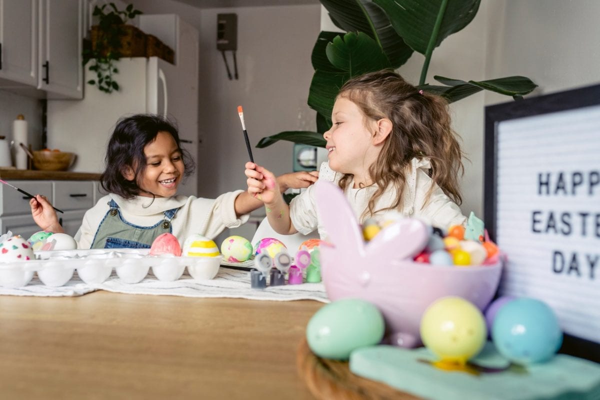 two young girls painting Easter eggs in the kitchen with child custody during school holidays issues resolved