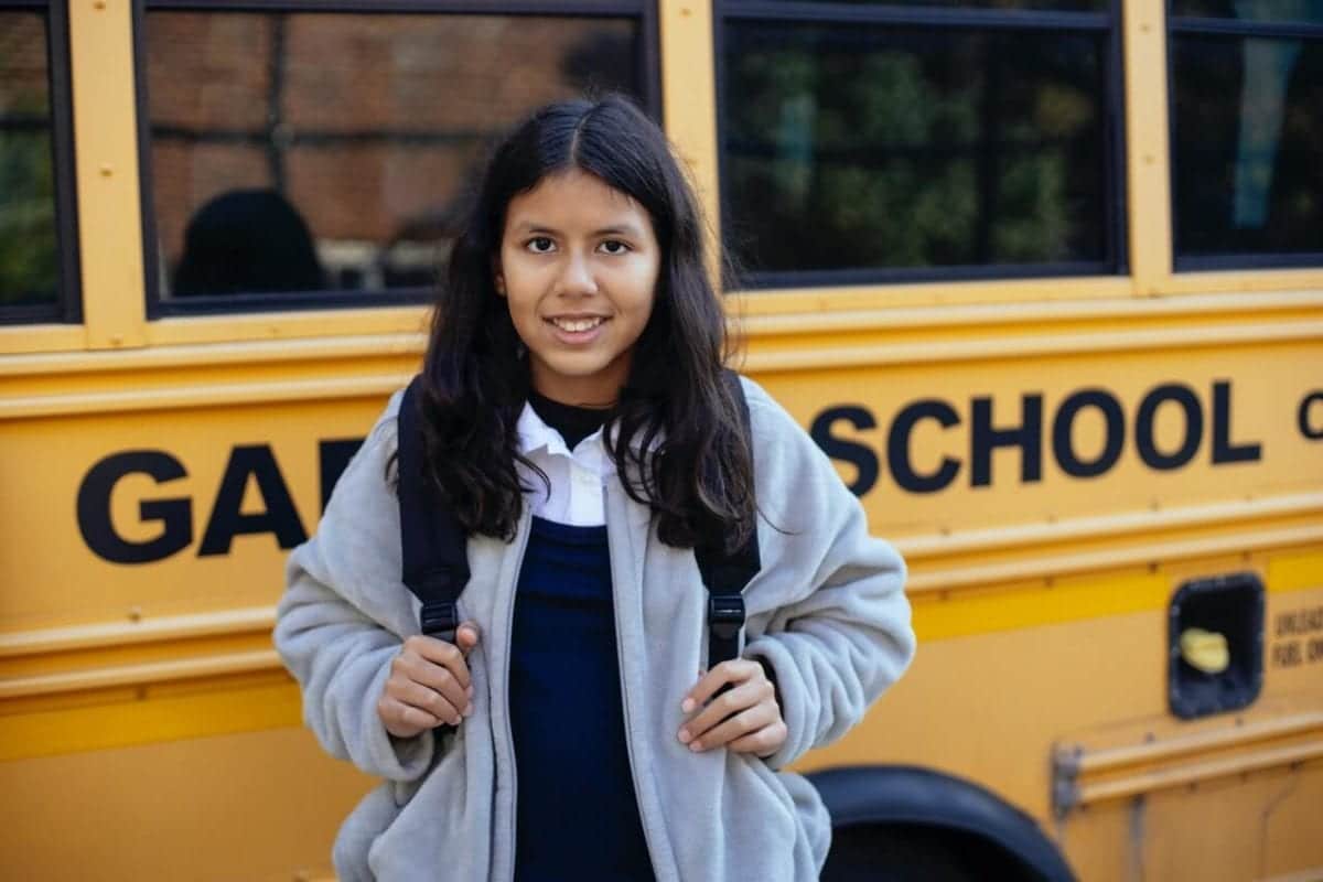 Girl boarding yellow school bus following parental separation