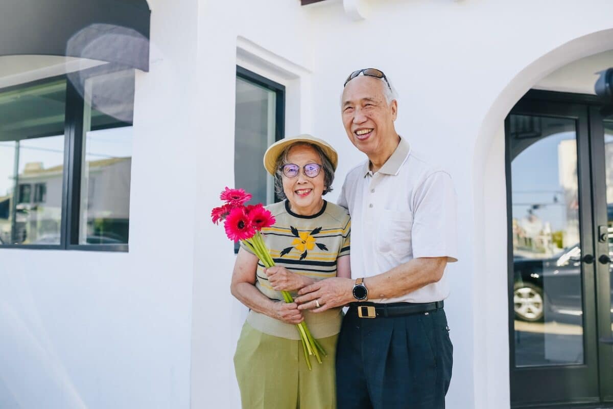 Adorable senior couple holding a bouquet of flowers defying the odds of Australian divorce rates.